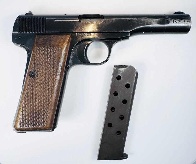 FN Browning Model 1922 beside its detached steel magazine, showing circular inspection holes and walnut grip checkering.