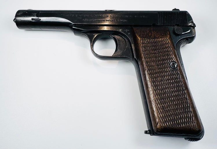 WWII FN Browning Model 1922 displaying stamped slide lettering, a rounded trigger guard, and a brown walnut grip.