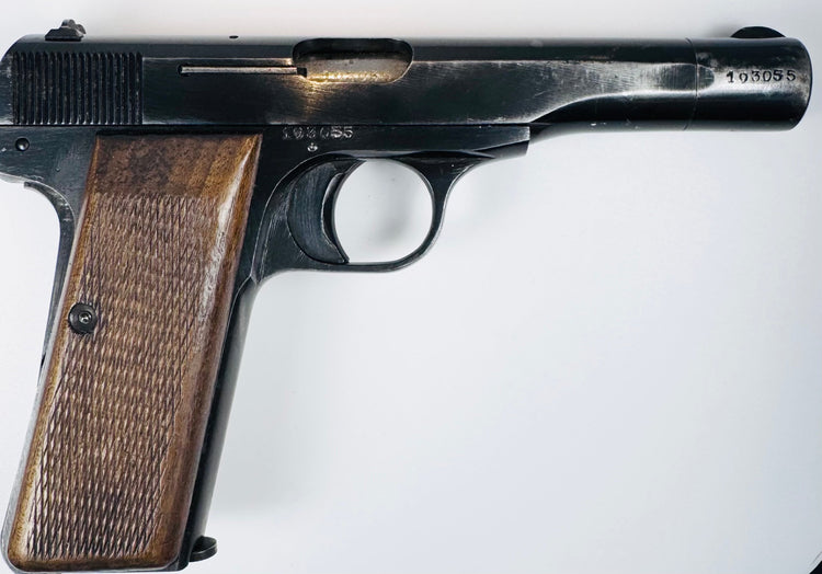FN Browning Model 1922 highlighting the ejection port, curved trigger, and textured walnut grip secured by a screw.
