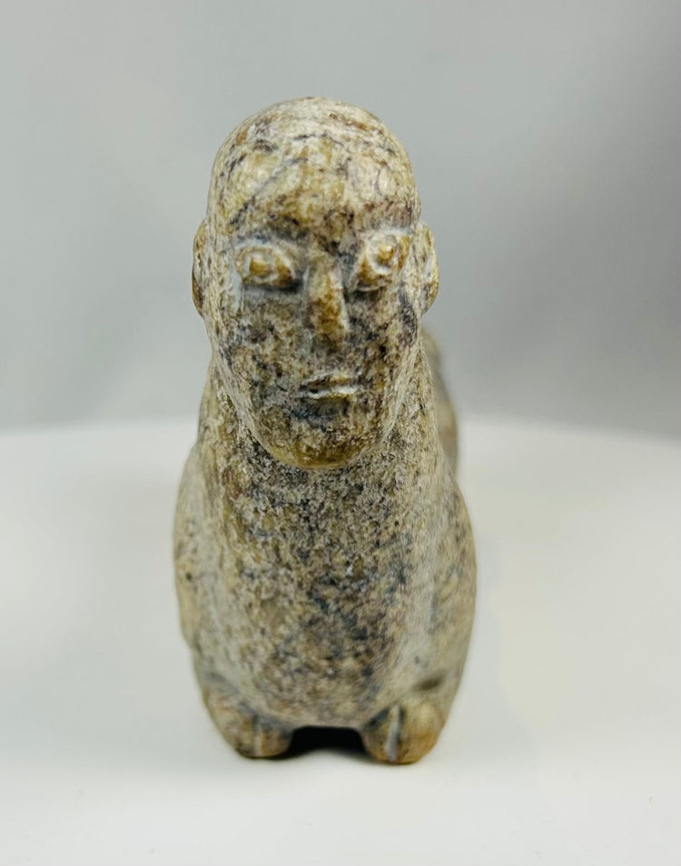 Hand carved stone effigy from West Africa with elongated body and upright neck