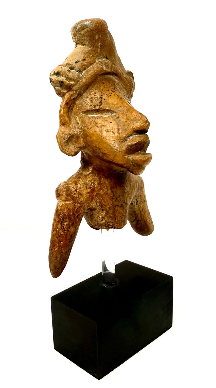 Side profile of brown fired clay figure with prominent nose and incised eye
