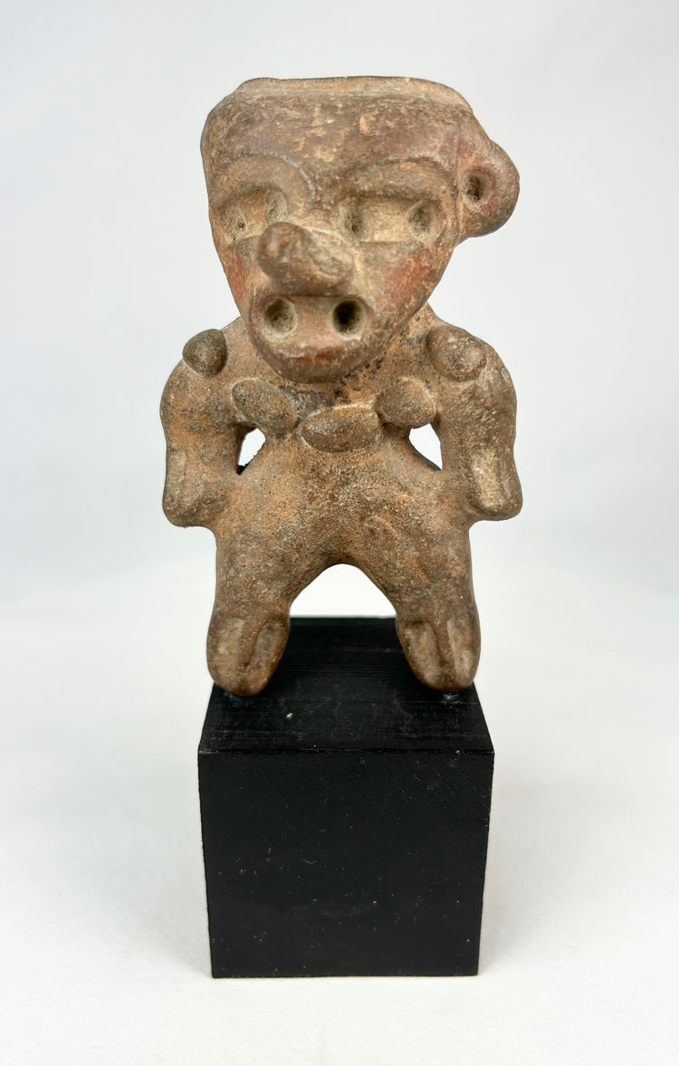 Ancient Pre-Columbian terracotta standing figure from West Mexico (Nayarit/Colima/Jalisco), circa 300 BCE–500 CE, with stylized head, pierced ears, and wide stance, mounted on a black display base, photographed on a white background