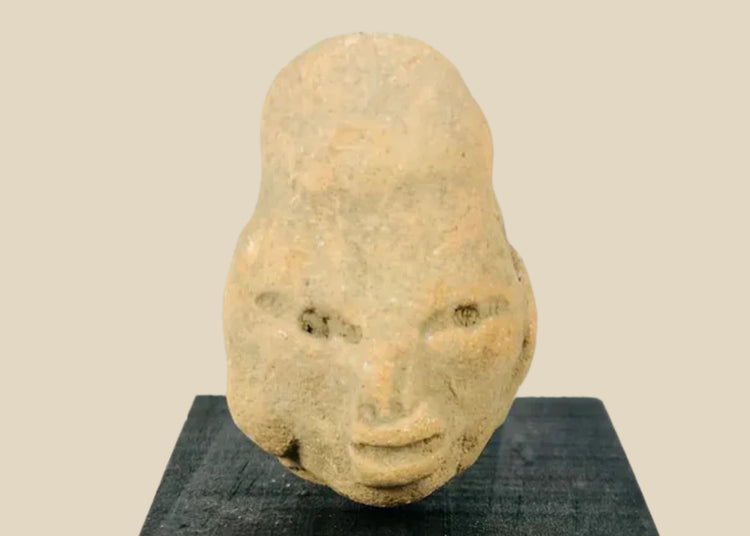 Small Pre-Columbian terracotta head fragment from West Mexico shaft-tomb culture, circa 300 BCE–300 CE, with almond-shaped eyes, defined features, and elongated cranial form, mounted on a black display base, photographed on a white background.
