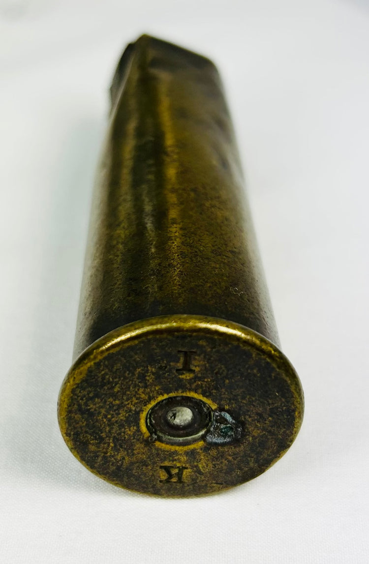 WWI-era military artifacts including soldier’s compass, shell casing, and unit photo on white background