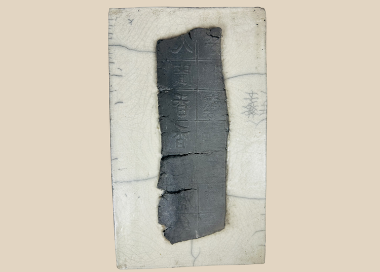 Ancient Chinese inscribed ceramic fragment mounted on backing with grid pattern and stylized characters