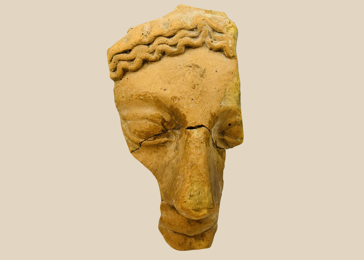 Ancient Greco-Roman terracotta theatrical mask fragment with stylized hair and closed eyelids