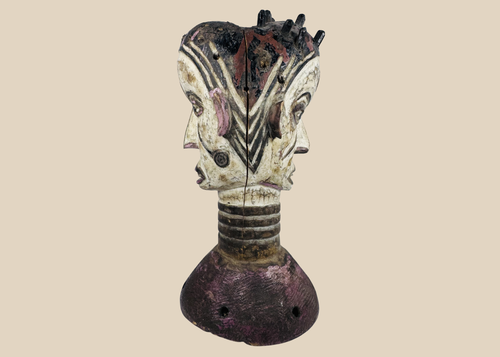 Nigerian Igbo Janus dance crest featuring opposing carved faces, painted decoration, and ceremonial masquerade symbolism.