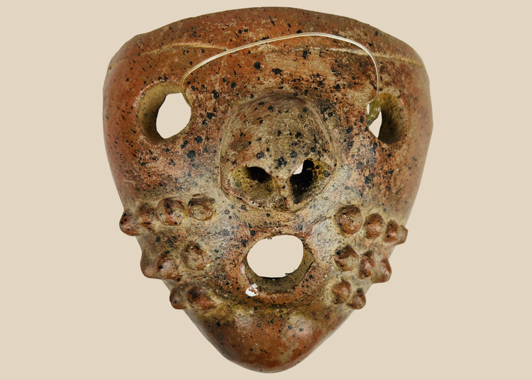 Pre-Columbian terracotta mask with perforated eyes and nodular cheek decoration