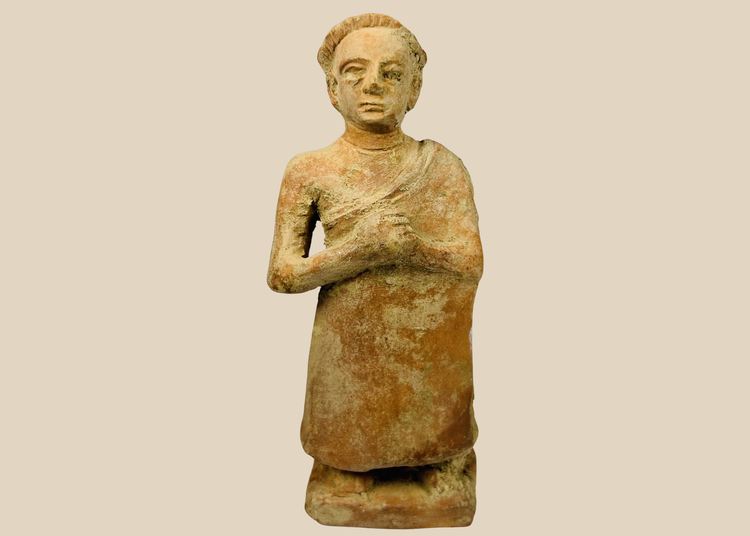 Primitive terracotta standing male figure with clasped hands