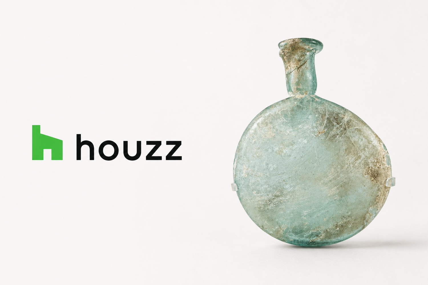 Houzz logo beside an ancient Roman pale green glass flask, featured by Relic & Rarity for an article on integrating Greco-Roman antiquities into luxury interiors.