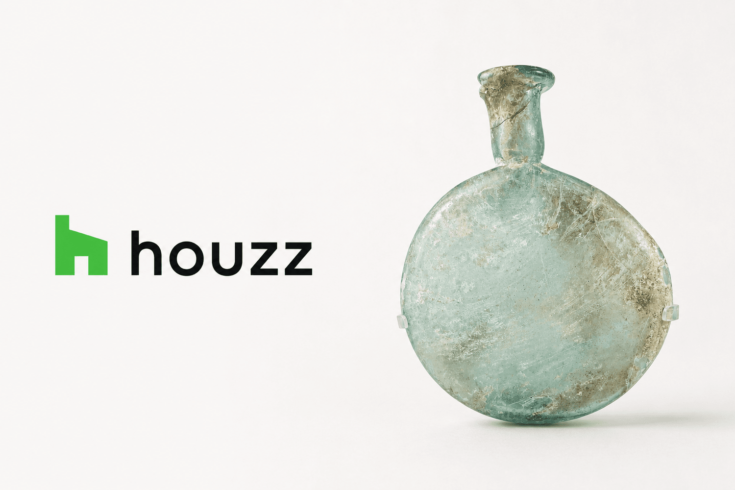 Houzz logo beside an ancient Roman pale green glass flask, featured by Relic & Rarity for an article on integrating Greco-Roman antiquities into luxury interiors.