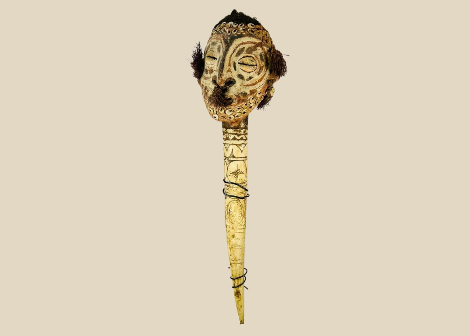 Papuan carved ceremonial ancestor figure with painted facial detailing and feathers, mounted on a long handle.