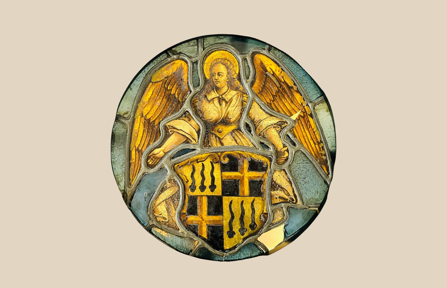 Antique stained glass roundel featuring an angel holding a heraldic shield, medieval-style artwork.