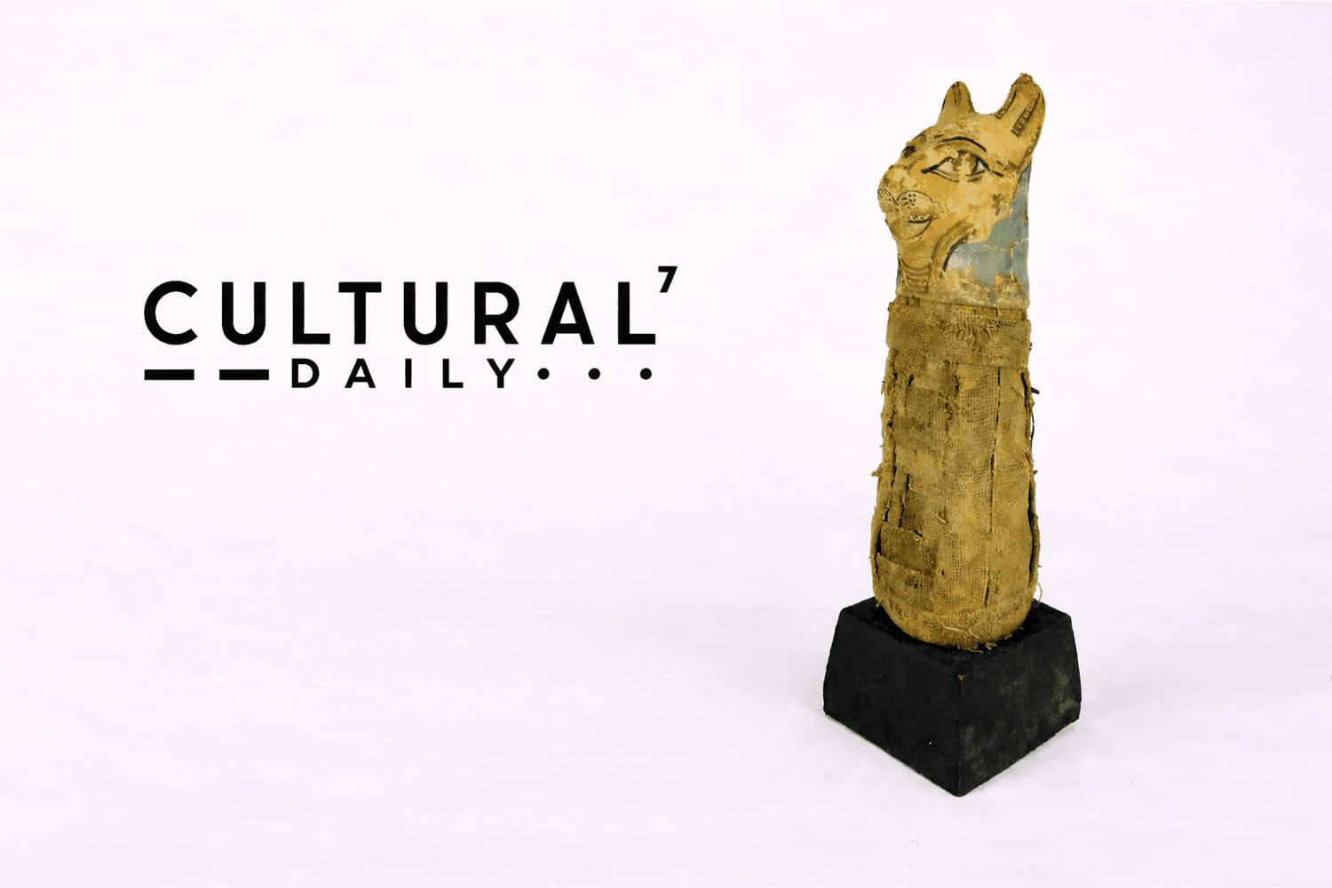 Cultural Daily publication logo displayed beside an ancient Egyptian Bastet votive cat mummy with linen wrappings mounted on a display base against a neutral studio background.