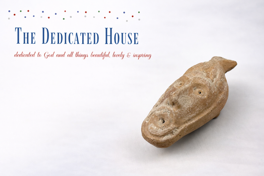 The Dedicated House blog logo with the tagline “dedicated to God and all things beautiful, lovely & inspiring” displayed beside an ancient terracotta animal-head artifact against a neutral studio background.
