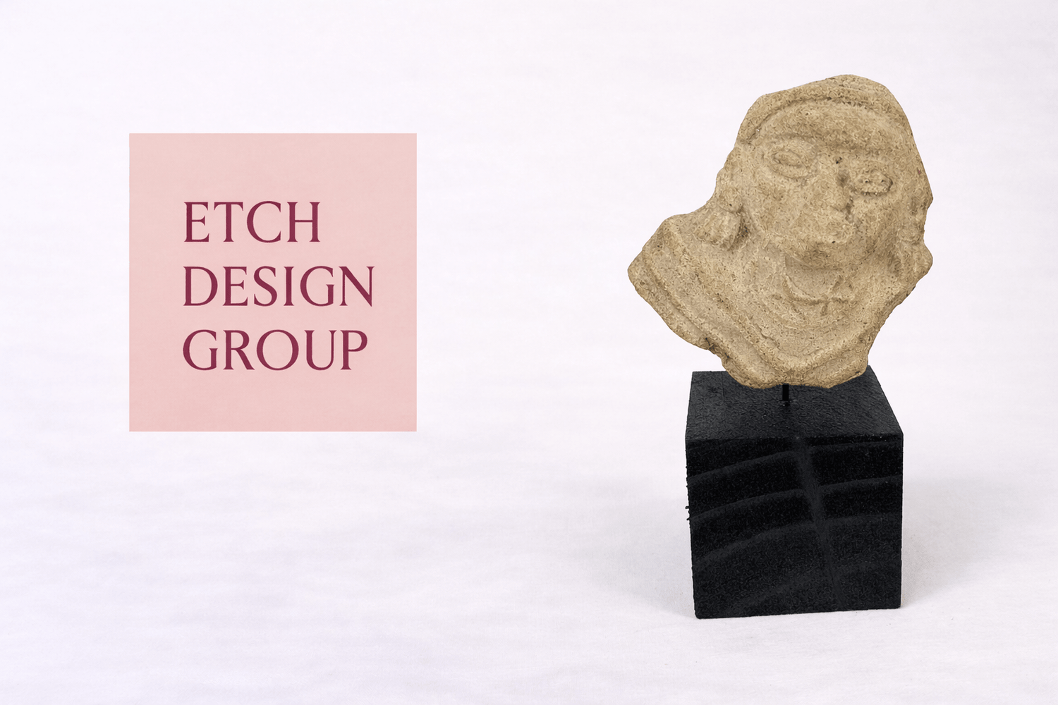 Etch Design Group interior design studio logo displayed beside an ancient carved stone head artifact from the Relic & Rarity collection.
