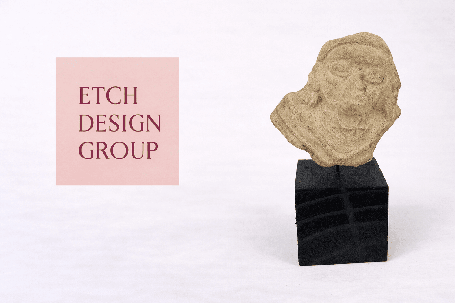 Etch Design Group interior design studio logo displayed beside an ancient carved stone head artifact from the Relic & Rarity collection.
