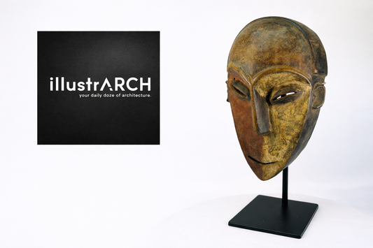 Illustrarch architecture publication logo displayed in a black square beside a carved African tribal mask mounted on a stand against a neutral studio background.