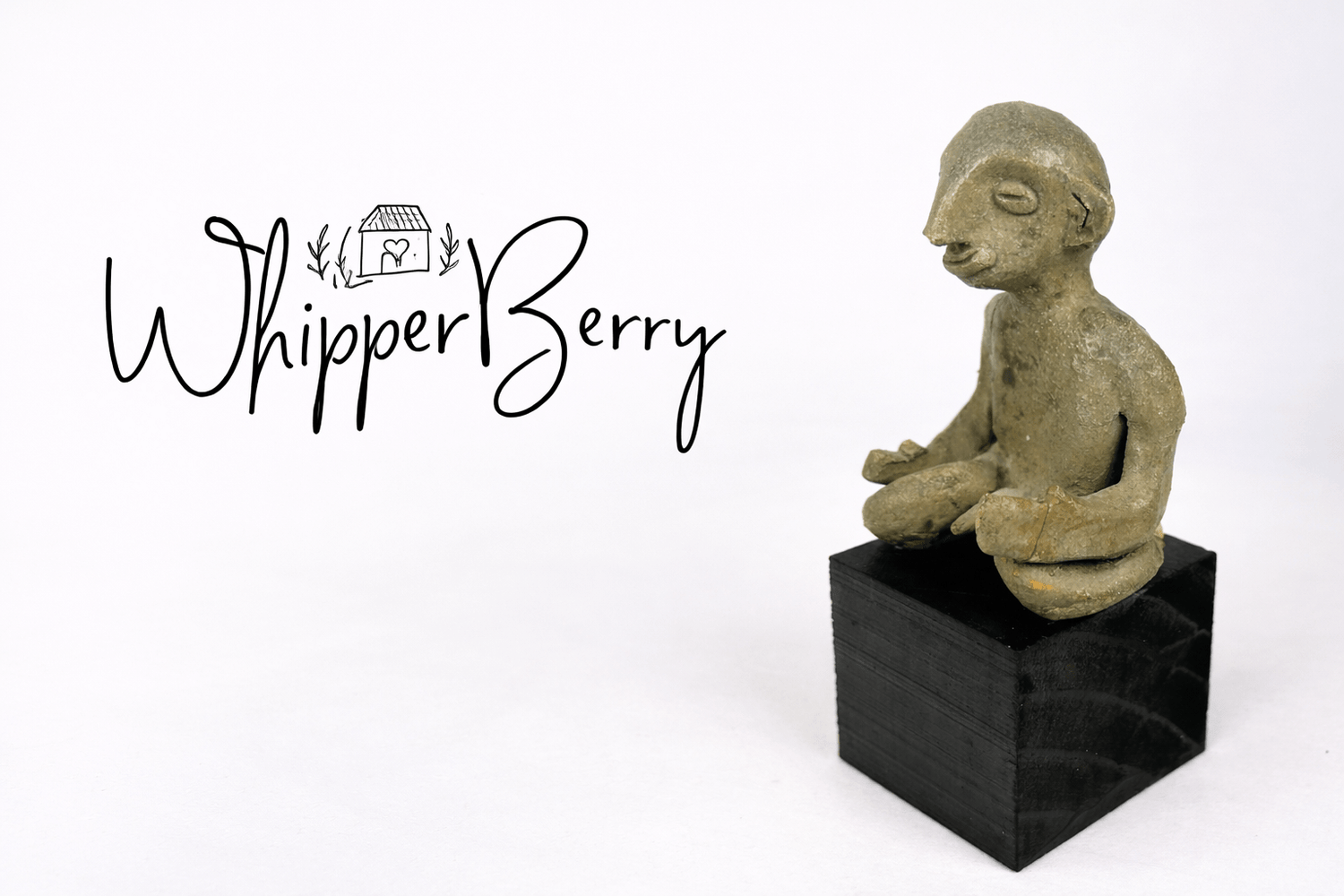 WhipperBerry blog logo displayed beside a small ancient terracotta seated figurine mounted on a black pedestal against a neutral studio background.