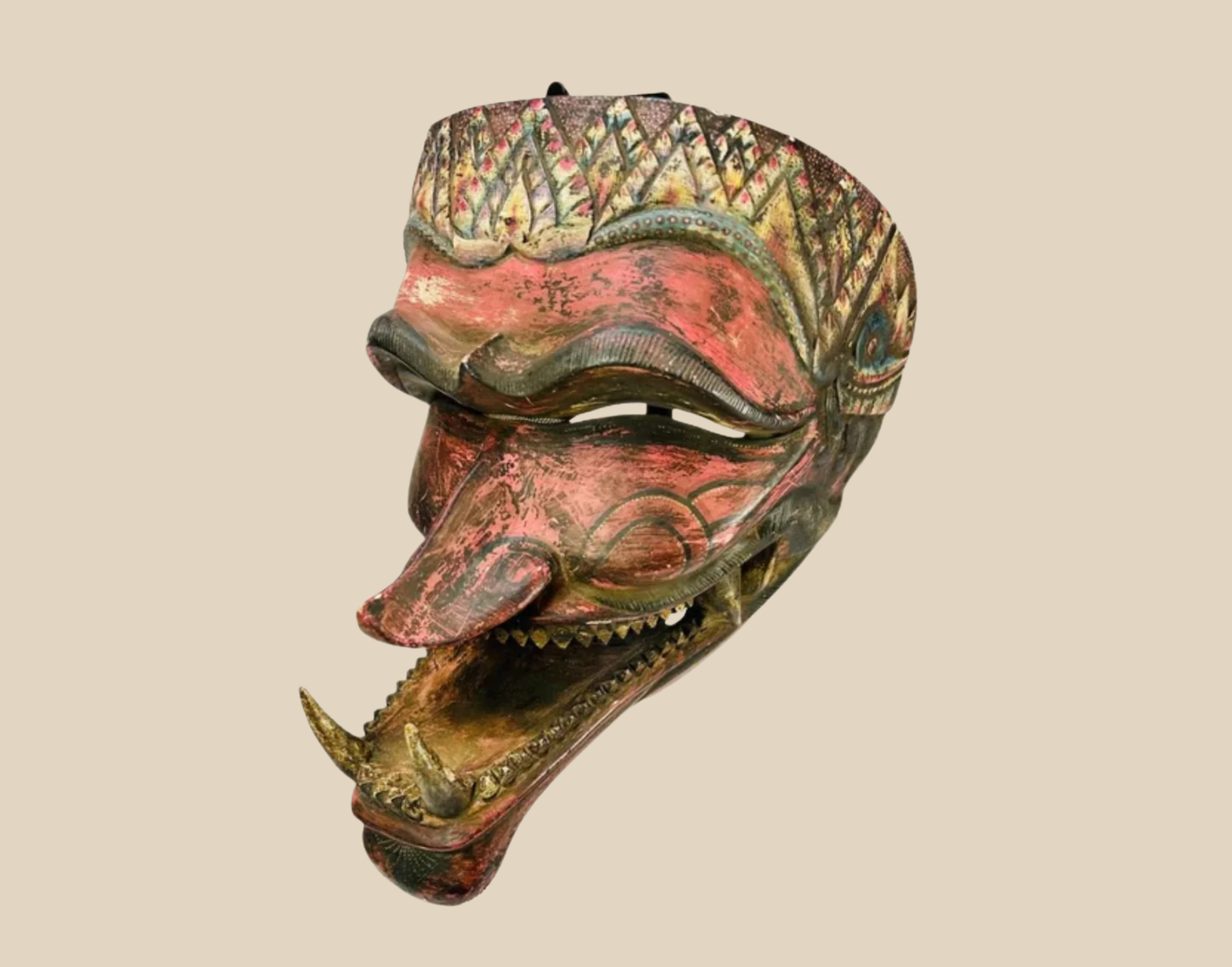 Antique Javanese hand-carved wooden mask with red and gold painted details, depicting a mythological character with an expressive open mouth
