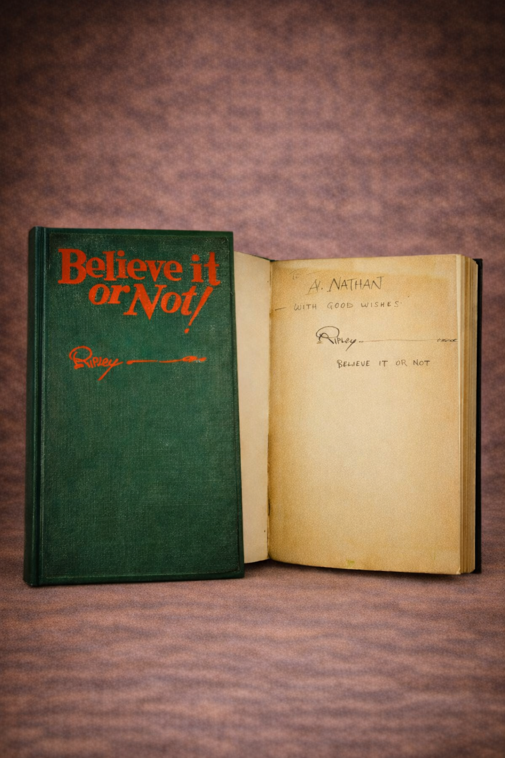 1929 Ripley’s Believe It or Not! hardcover book displayed beside an open, signed inscription page on a warm brown studio background.
