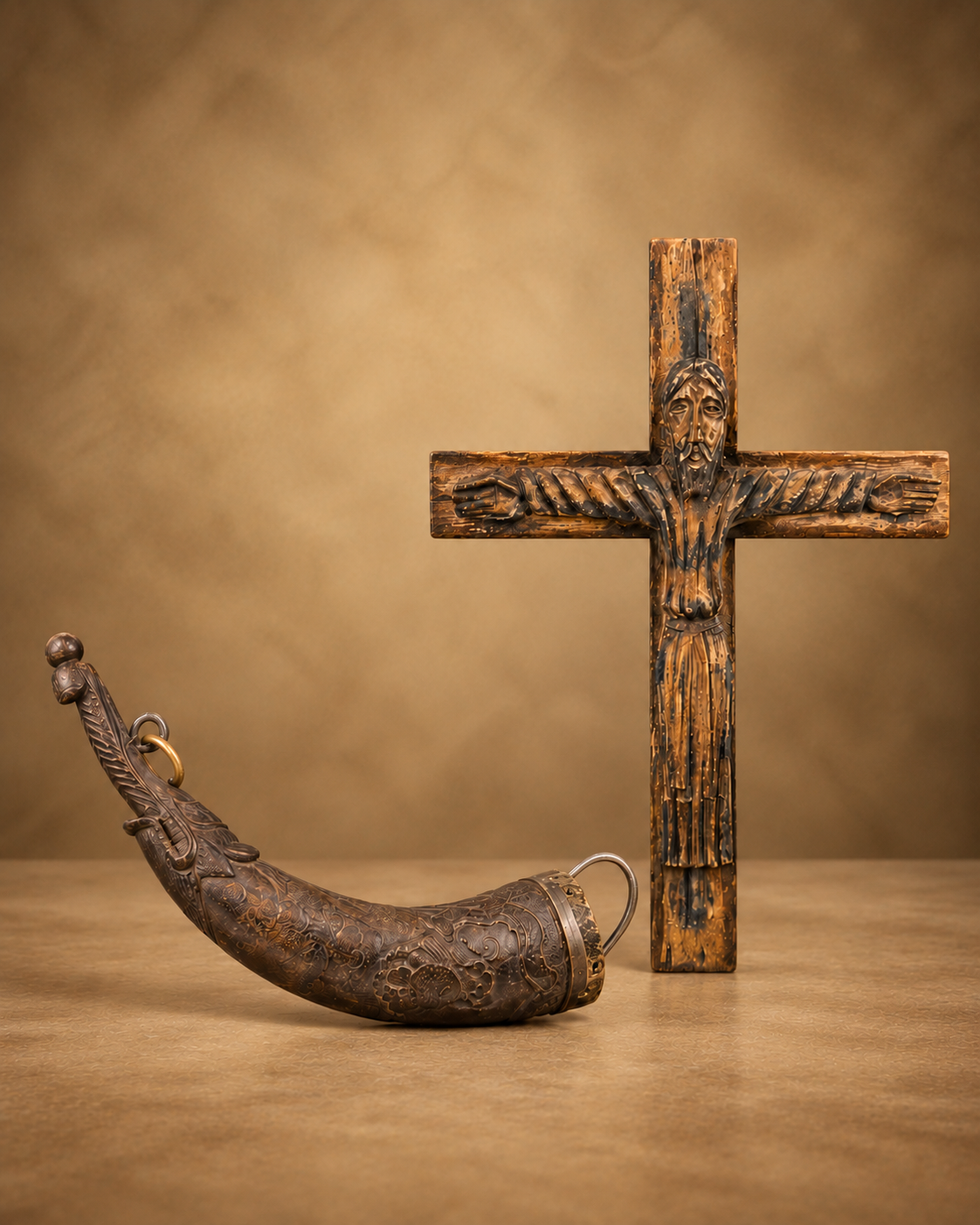 Antique religious and spiritual artifacts featuring a carved wooden crucifix and decorated devotional vessel displayed together.