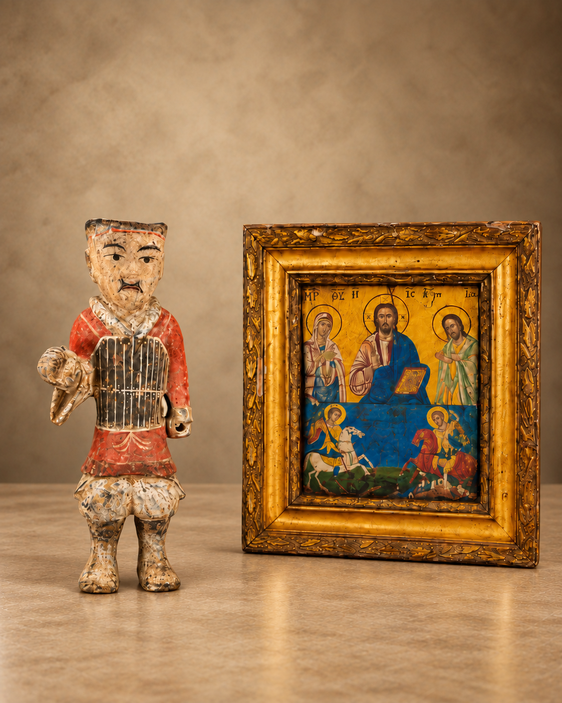 Antique collectibles featuring a painted standing figurine beside a framed religious icon with colorful devotional imagery.