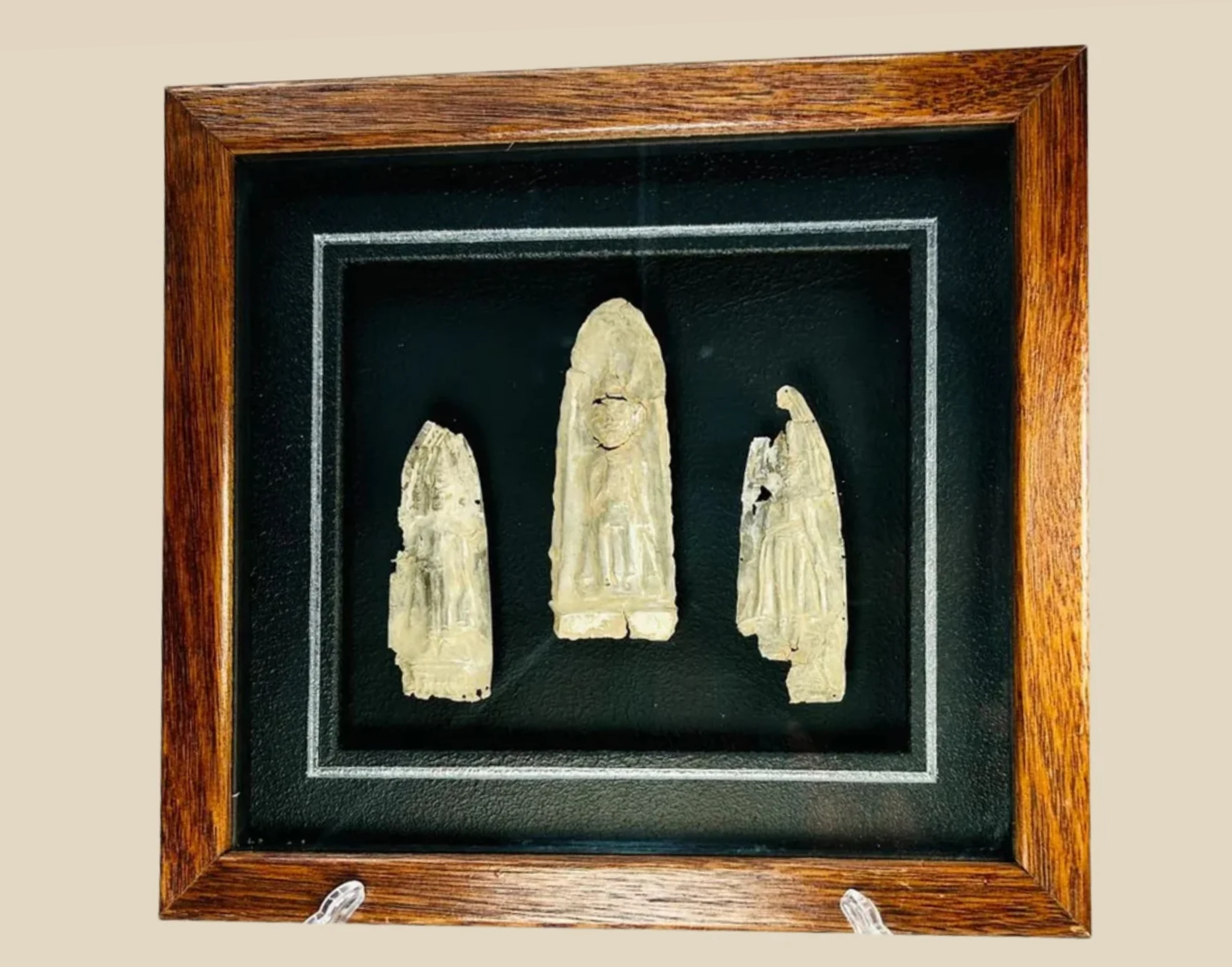 16th-century carved religious ivory or bone figures displayed in a wooden shadow box frame on black velvet background
