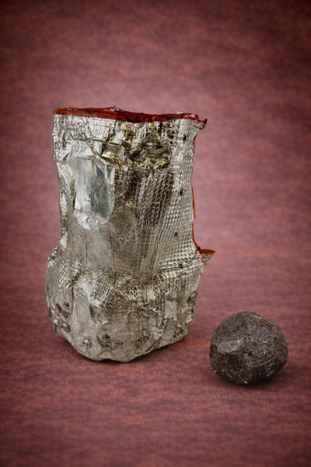NASA Space Shuttle insulation fragment displayed beside a small meteorite specimen on a neutral background.