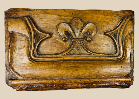 16th-century Gothic/Tudor carved oak panel featuring a detailed fleur-de-lis motif in high relief on a beige background.