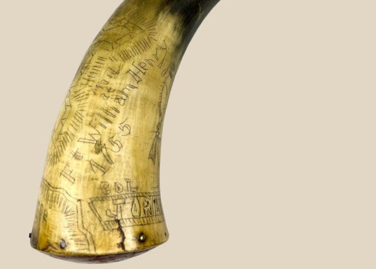 18th-century Colonial American powder horn dated 1755, engraved with Fort William Henry, Lake George, and figural scenes, polished bovine horn with wooden plug, displayed on a white background.