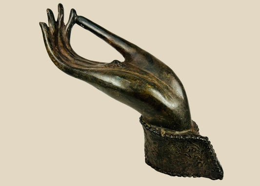 Bronze Buddha hand fragment from 18th–19th century Northern Thailand or Laos with elongated fingers, palm rosette/chakra, original wrist cuff with beaded edge, rich brown-olive patina, traces of lacquer and earthen accretions, representing Abhaya or Vitarka mudrā in Lanna/Lan Xang Buddhist art.
