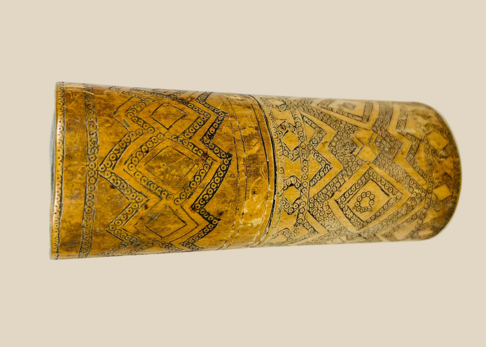 Antique carved bamboo container from Island Southeast Asia, 19th century, cylindrical with fitted lid and base, decorated with incised geometric patterns darkened with pigment, traditionally used for betel nut lime storage, photographed on a white background.