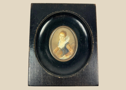 Mid–late 19th-century Continental European miniature portrait of a young woman in historicizing costume with deep blue bodice, amber sleeves, and lace ruff, watercolor/gouache on thin wafer, signed lower right, in ebonized wood frame with oval brass bezel, after Fragonard, circa 1860–1890.
