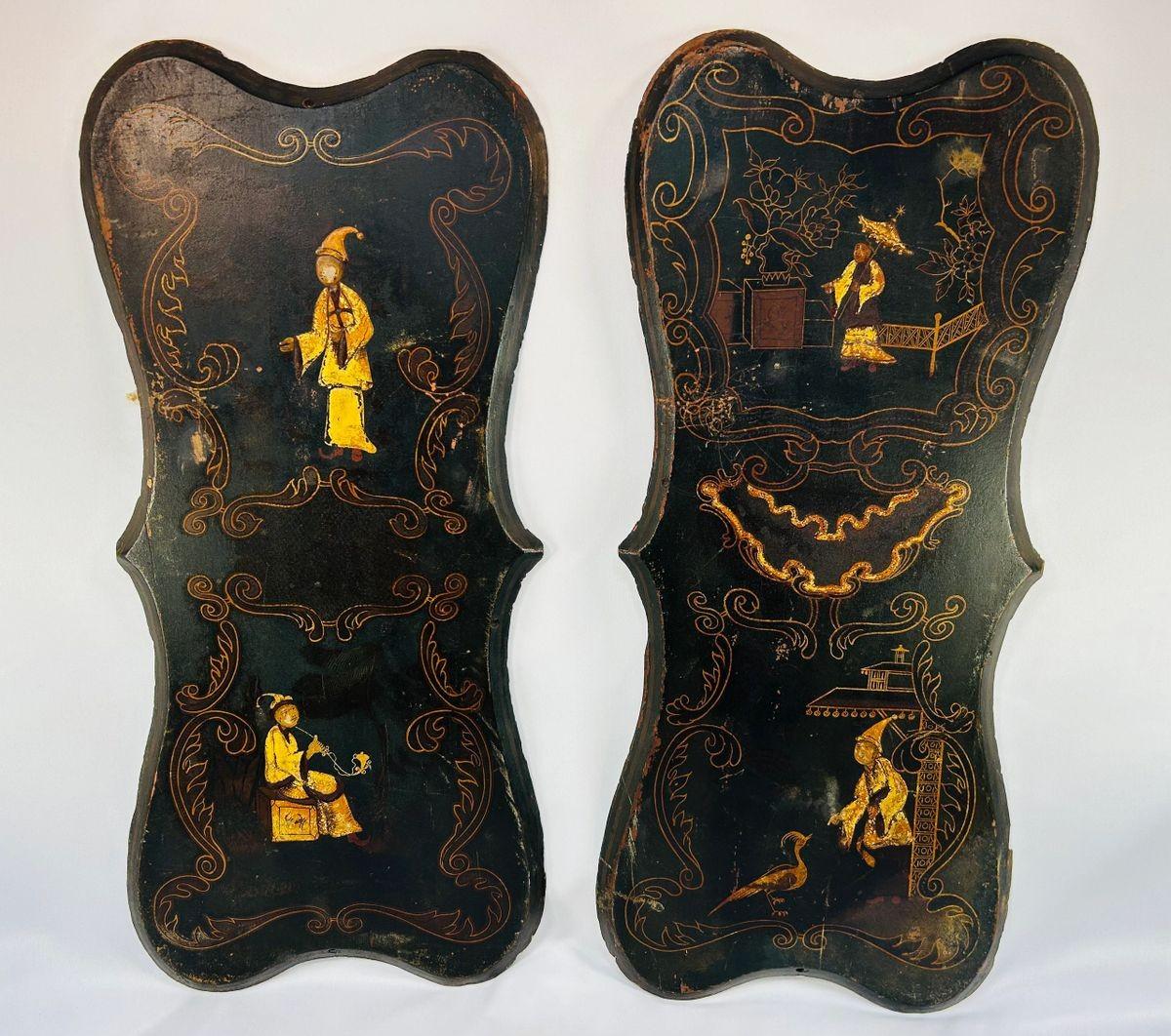 Pair of 19th-century Chinoiserie wall panels with hand-painted Asian-inspired figures, floral motifs, and gilt decoration on shaped black lacquered wood, circa 1850–1880.