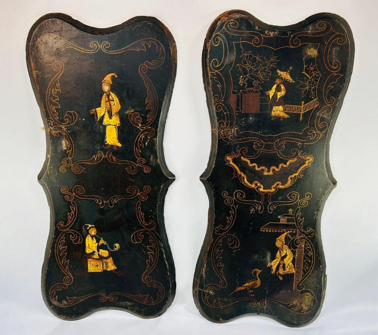 Pair of 19th-century Chinoiserie wall panels with hand-painted Asian-inspired figures, floral motifs, and gilt decoration on shaped black lacquered wood, circa 1850–1880.