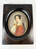 19th-century miniature portrait of a lady holding roses in an oval frame