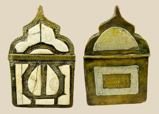 Ornate 19th-century Moroccan Berber amulet box with hinged pointed-arch lid, hammered brass body, carved bone inlay with geometric designs, and rich patina, used to house protective talismans and Quranic verses