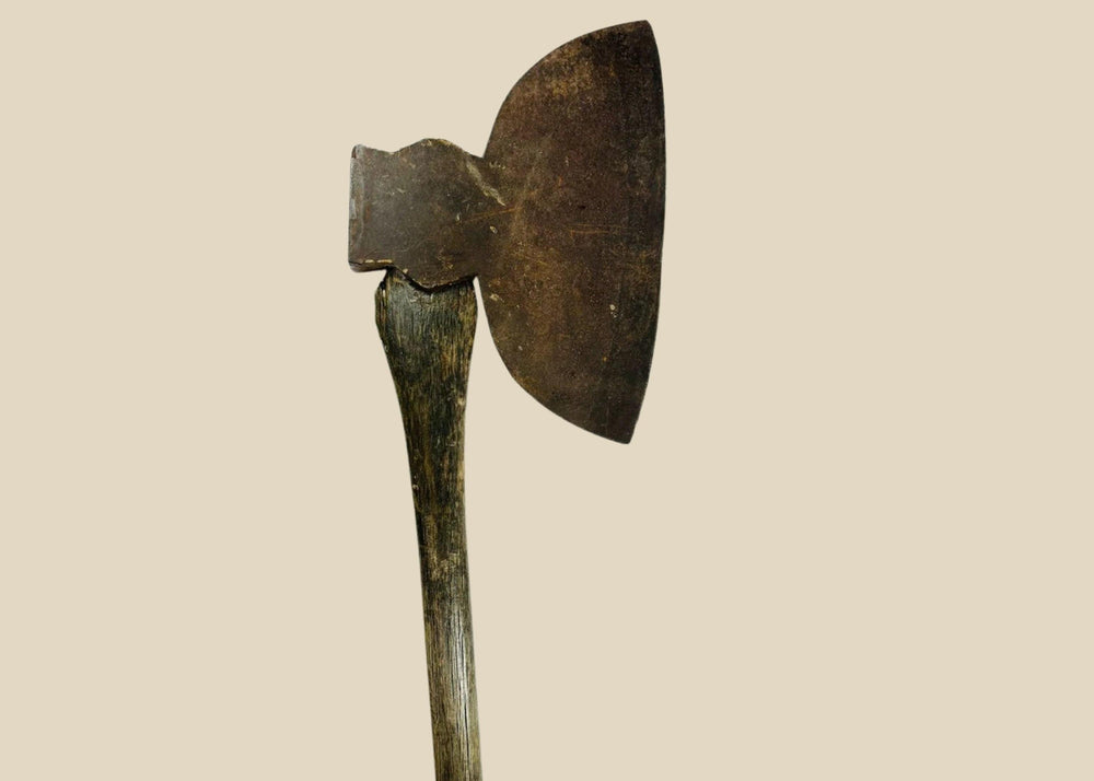 19th-century American broadhead axe with forged steel blade and flat reverse head, featuring a sturdy wooden handle, manufactured by M.H. Jones & Co., New York, used for woodcutting and frontier tasks.