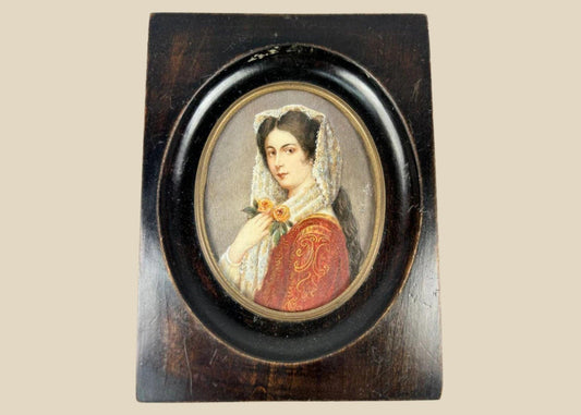 Miniature 19th-century portrait painting of a young woman in red embroidered attire with a lace mantilla, holding two yellow roses, signed “Kimsky,” framed in oval ebonized wood with brass bezel.