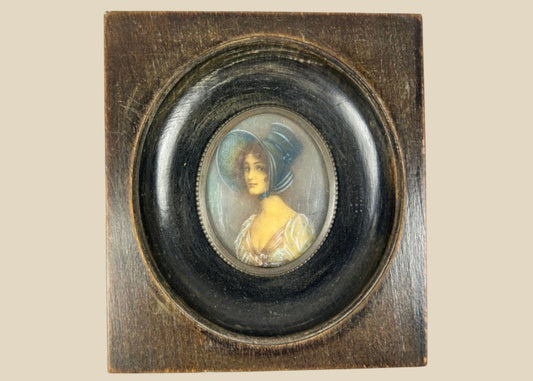Antique 19th-century Viennese miniature portrait of a woman in blue bonnet and lace gown, painted in gouache on wafer, in original ebonized wooden frame with convex glass.