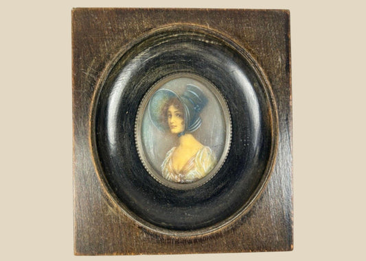 Antique 19th-century Viennese miniature portrait of a woman in blue bonnet and lace gown, painted in gouache on wafer, in original ebonized wooden frame with convex glass.
