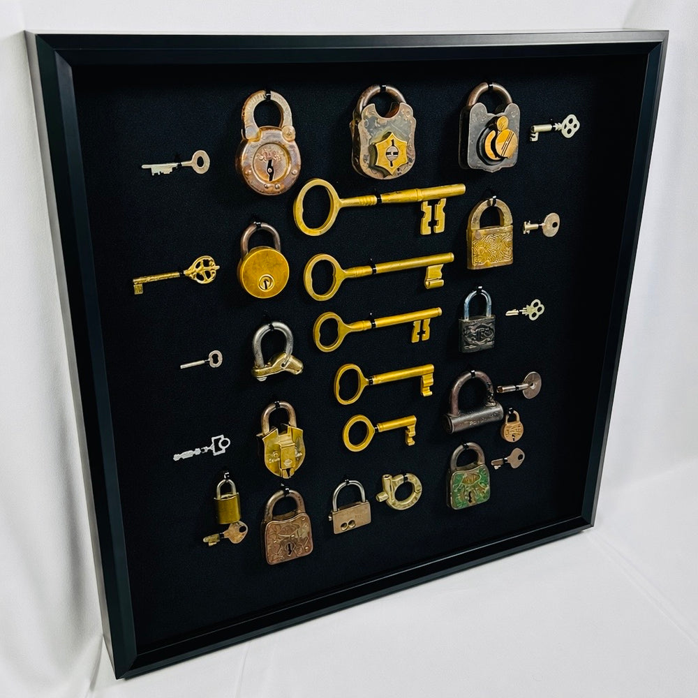 Framed display of antique brass and iron locks with matching keys showcasing early security mechanisms