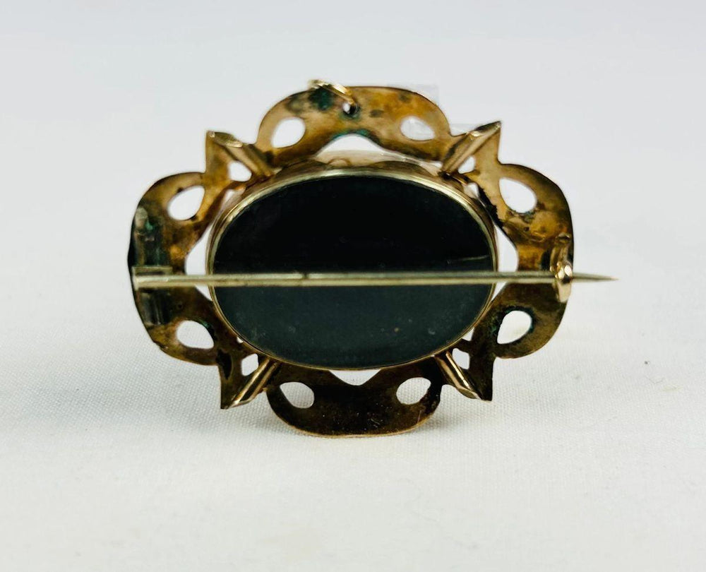Detail of Gothic Revival openwork on a gold-plated Victorian mourning brooch.