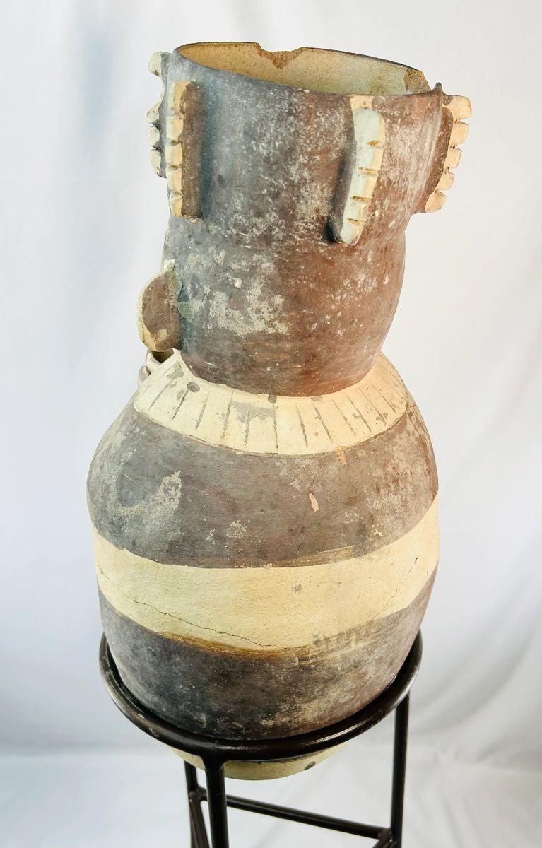Ancient Peruvian effigy urn featuring detailed headdress and geometric decoration