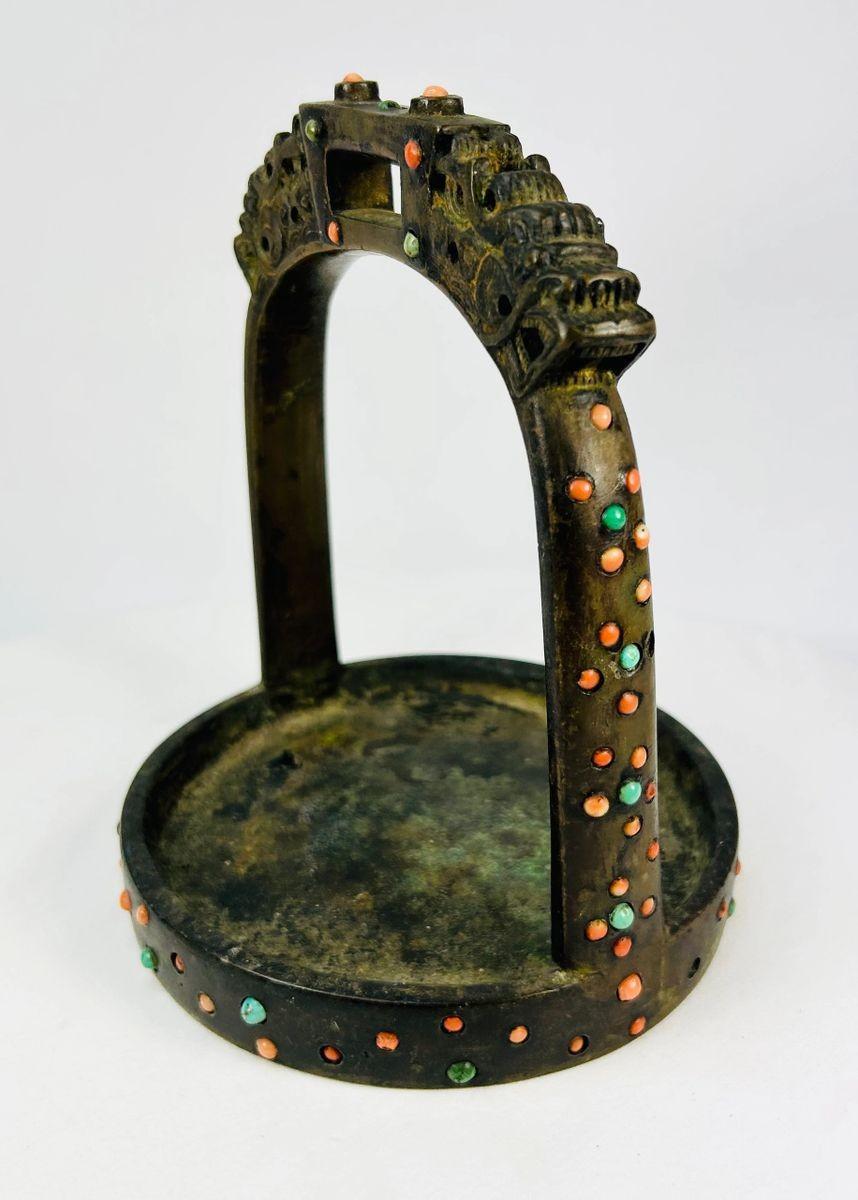 Macro detail of bronze latticework and inlaid stones on ceremonial Mongol–Tibetan stirrup.