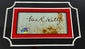 Authentic signature of George “Machine Gun Kelly” Barnes on aged paper with COA hologram, mounted in red and black archival frame, circa 1930s.