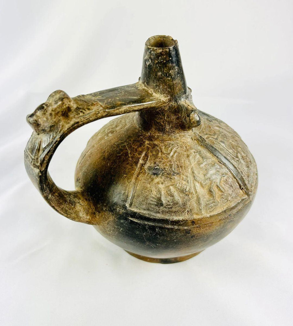 Side view of Sicán Lambayeque blackware bottle highlighting sculpted handle and polished ceramic body, ancient Peru.