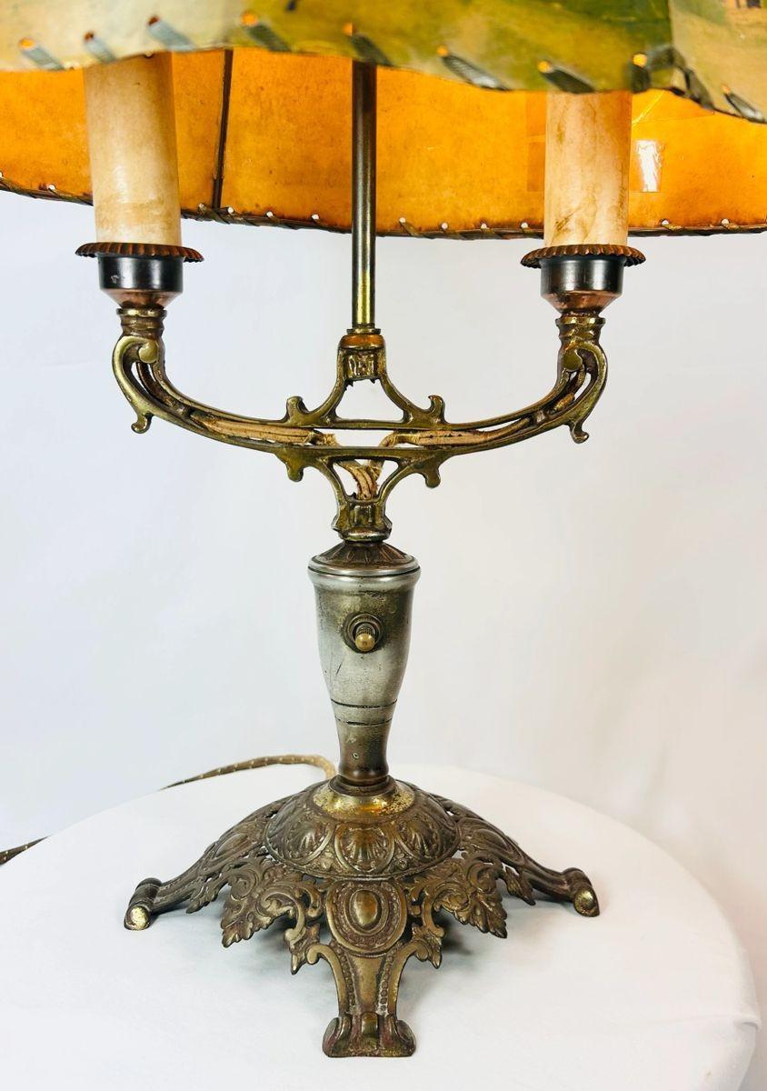 Museum-style display of a 1920s European Art Nouveau table lamp with painted parchment shade