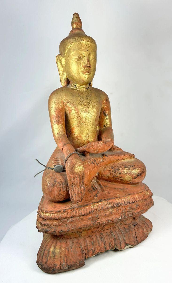 Front view of a carved Burmese Buddhist monk statue seated in meditation